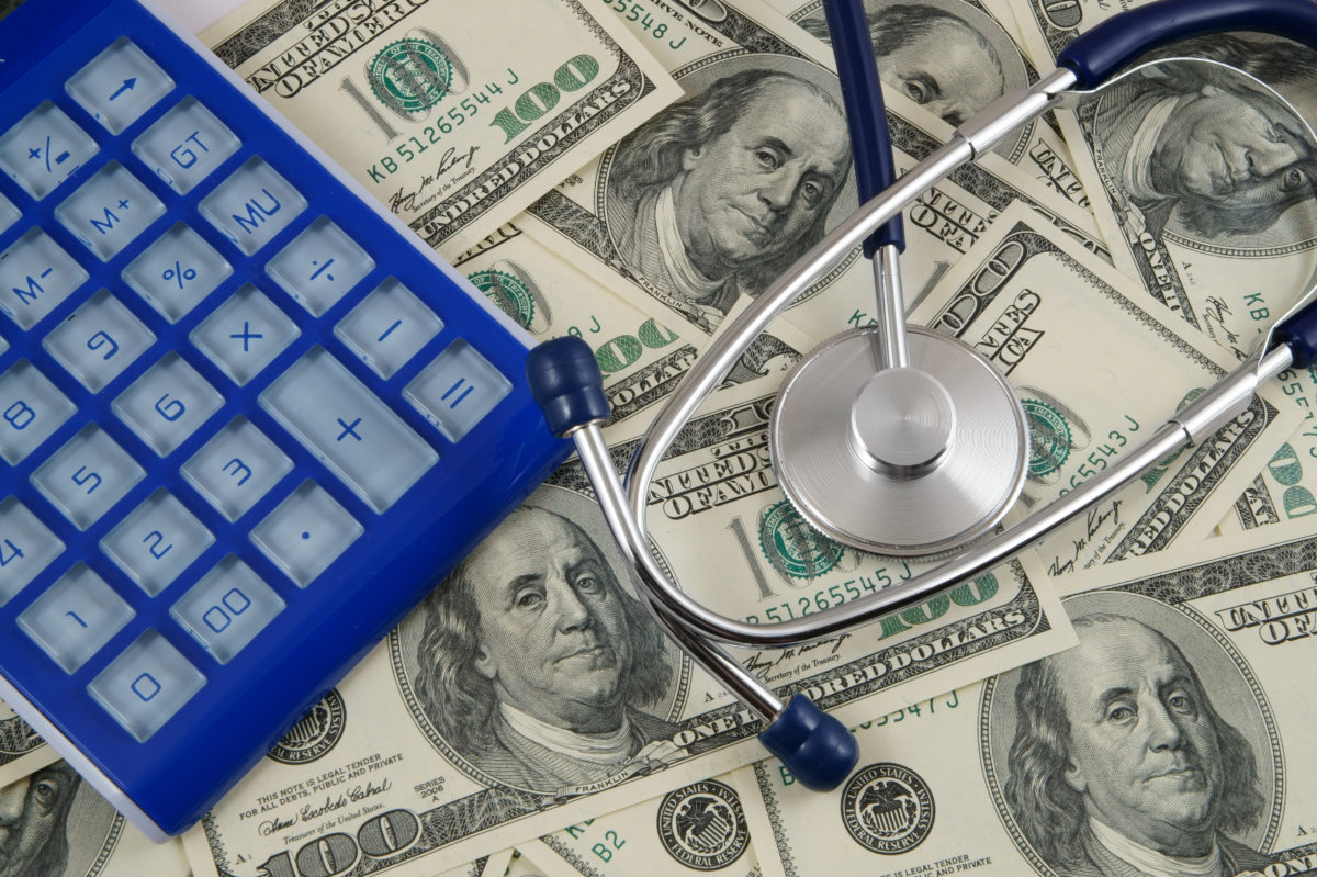 money, calculator, and stethoscope