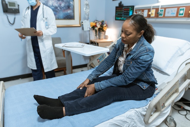 woman on hospital bed holding leg