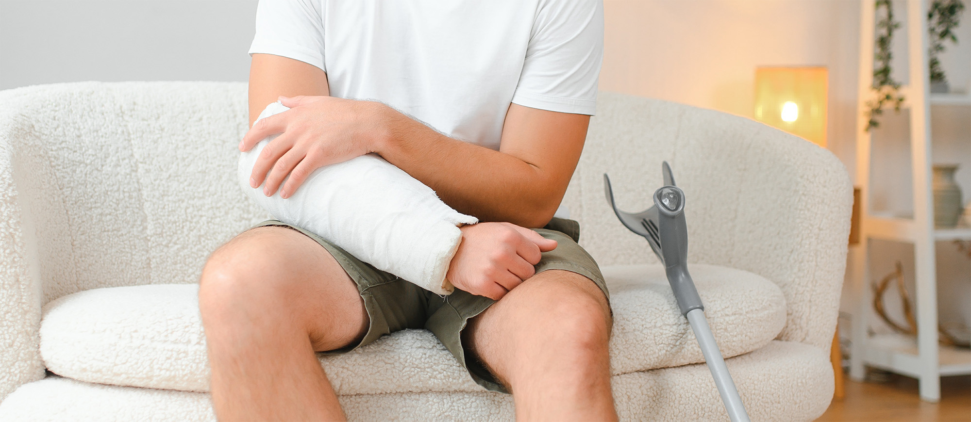 Sad unlucky young man with broken leg injured arm