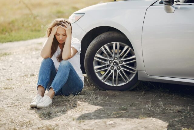 stressed woman sitting outside of car