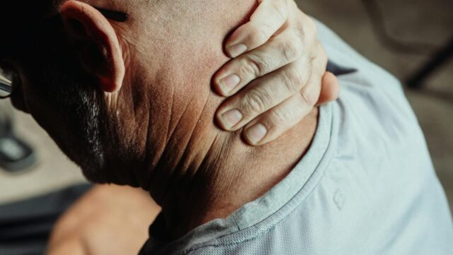man holding neck in pain